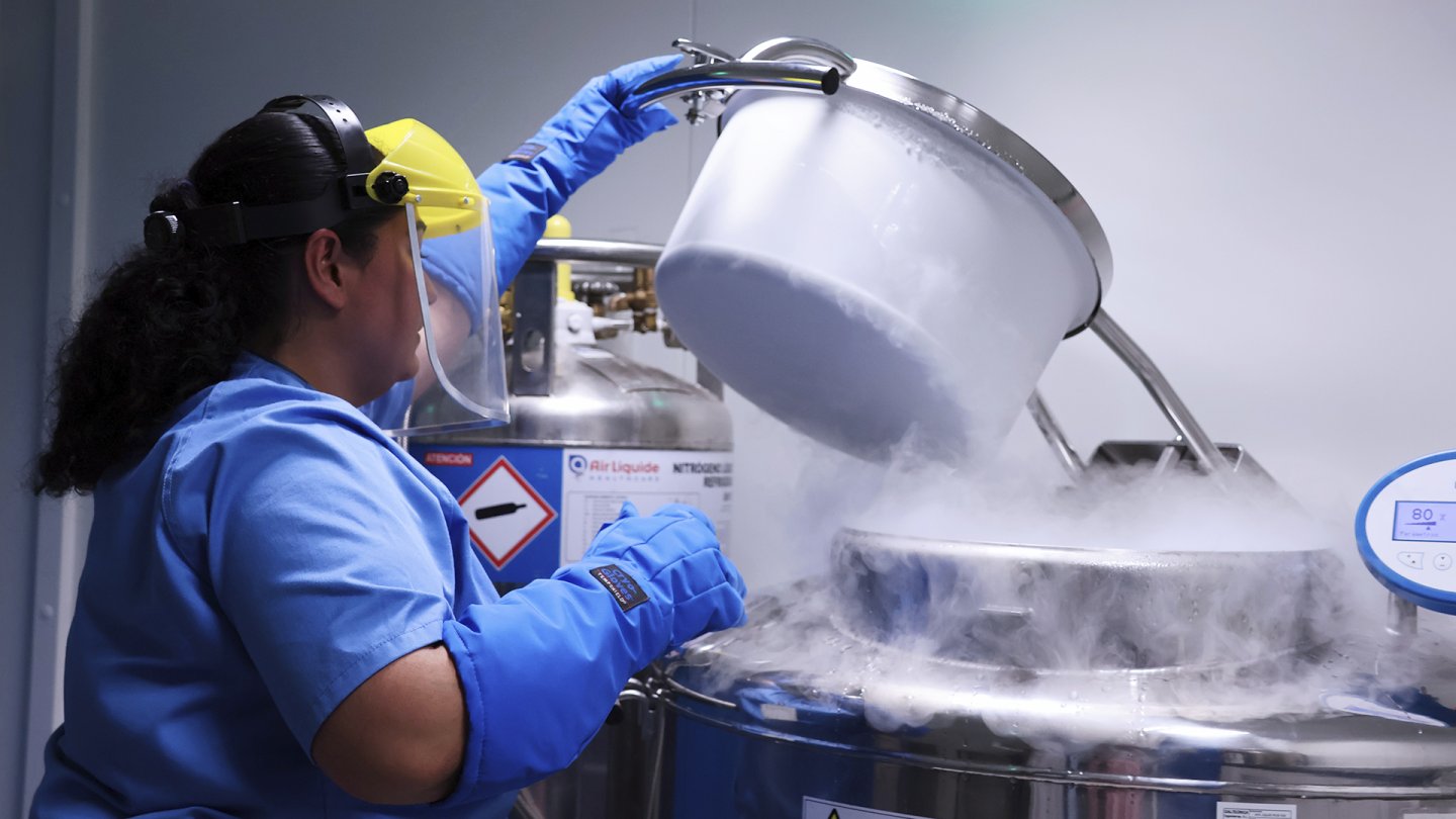 The picture of a woman opening a freezer with samples.