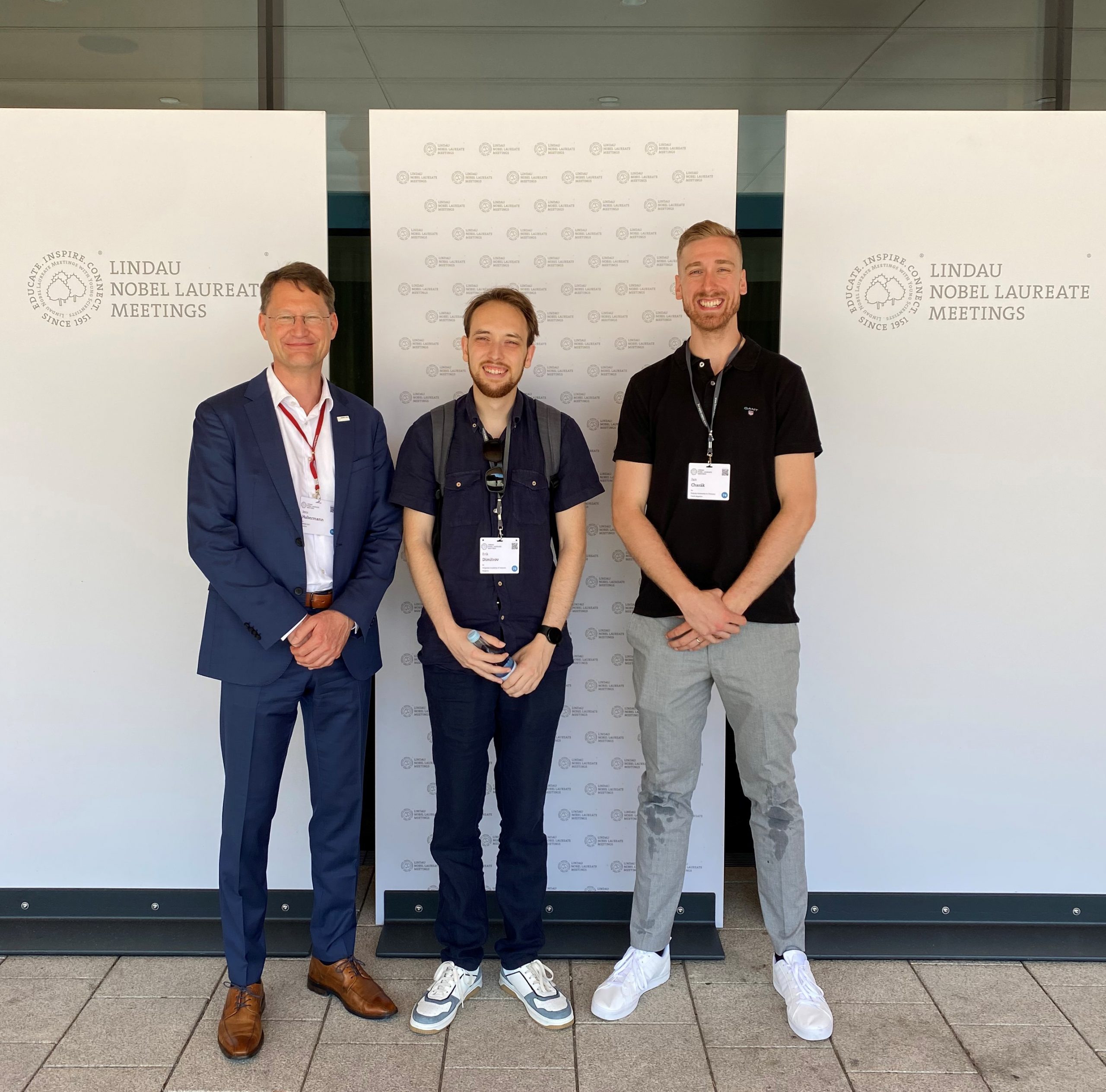 The picture of 3 men smiling in front of the camera